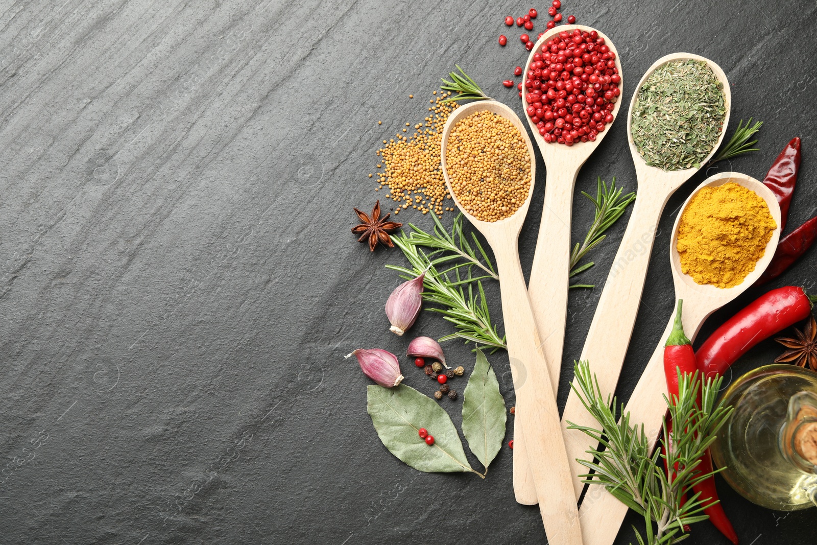 Different aromatic spices in spoons on black table, flat lay. Space for text Photo of Different aromatic spices in spoons on black table, flat lay. Space for text