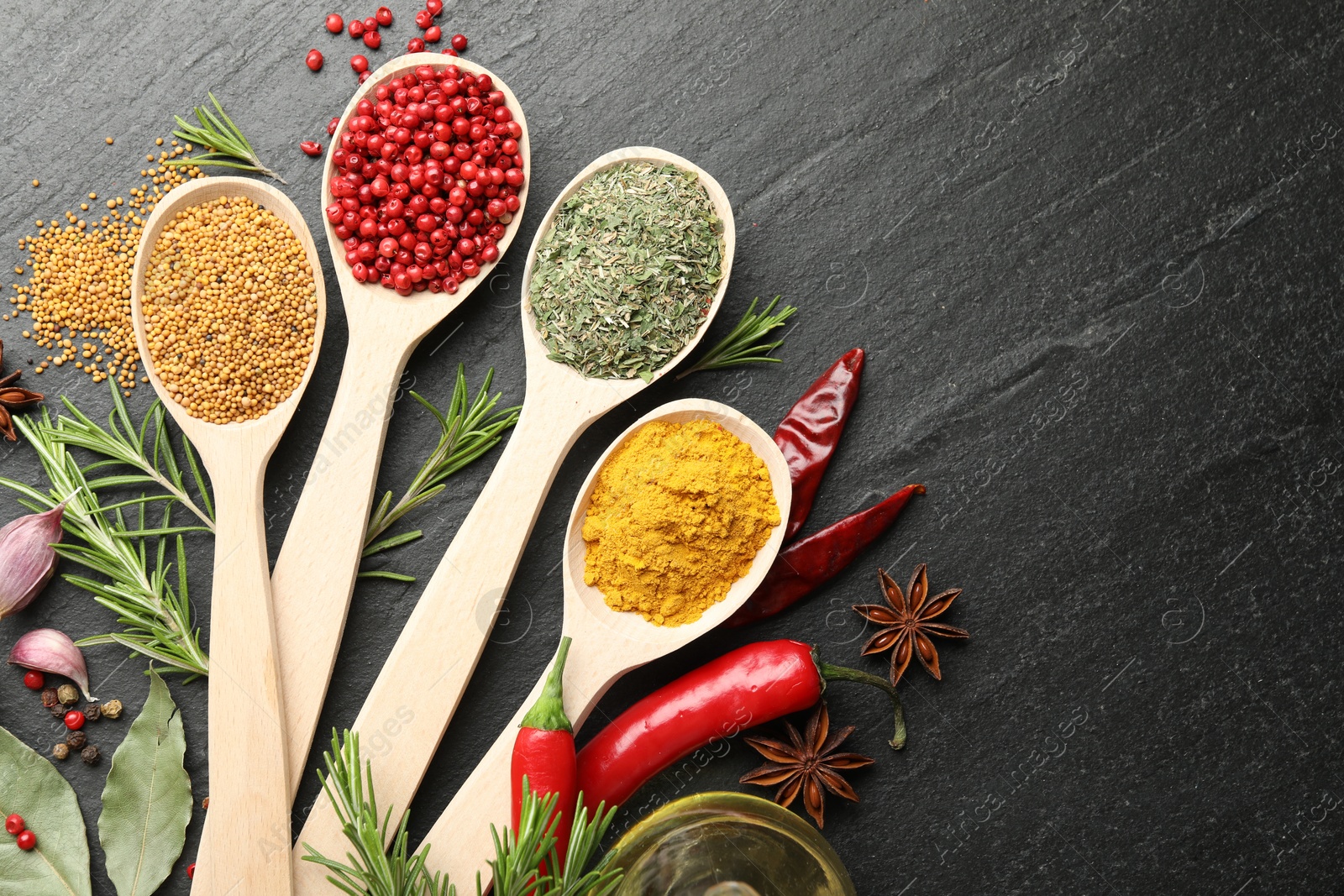Different aromatic spices in spoons on black table, flat lay. Space for text Photo of Different aromatic spices in spoons on black table, flat lay. Space for text
