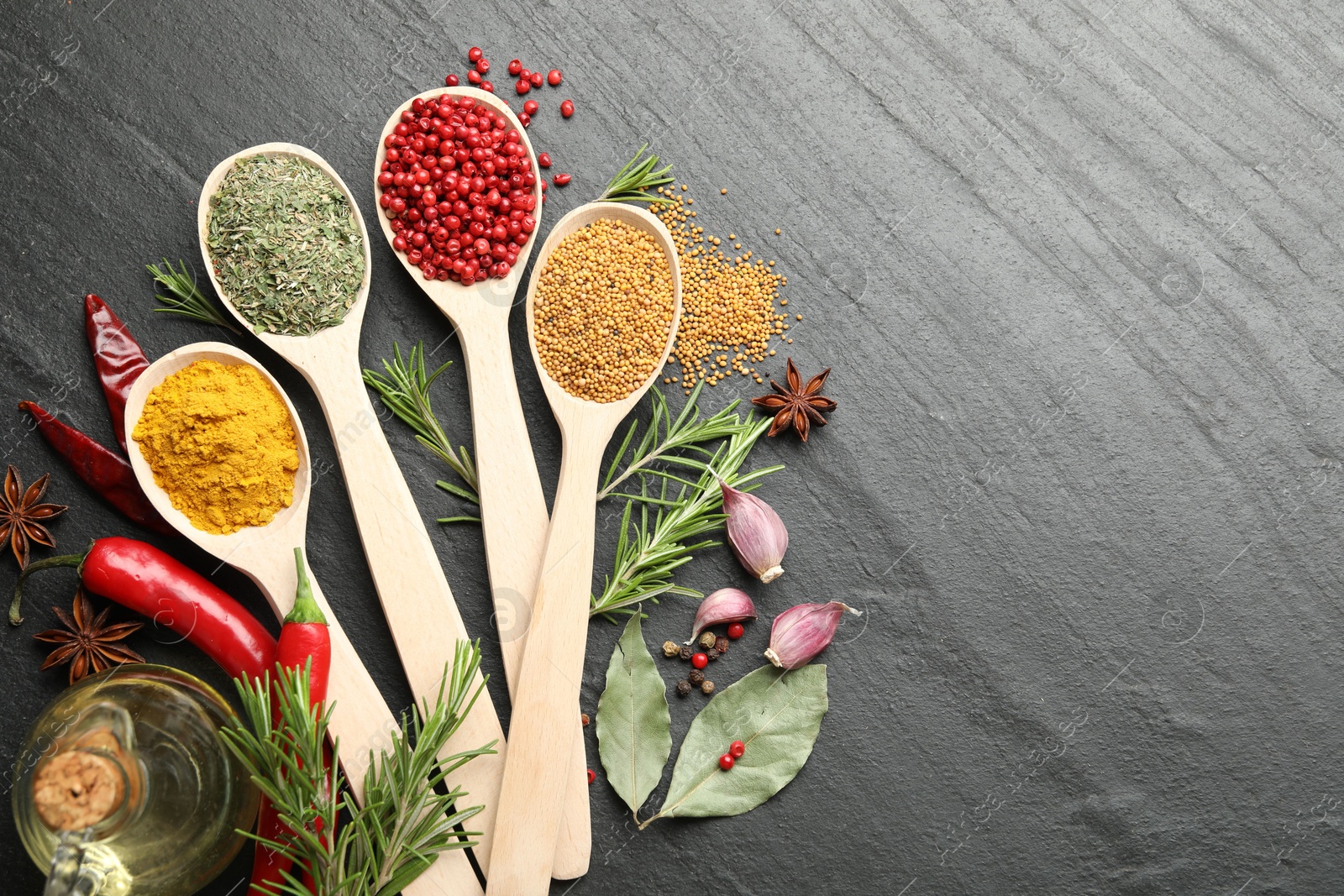 Different aromatic spices in spoons on black table, flat lay. Space for text Photo of Different aromatic spices in spoons on black table, flat lay. Space for text