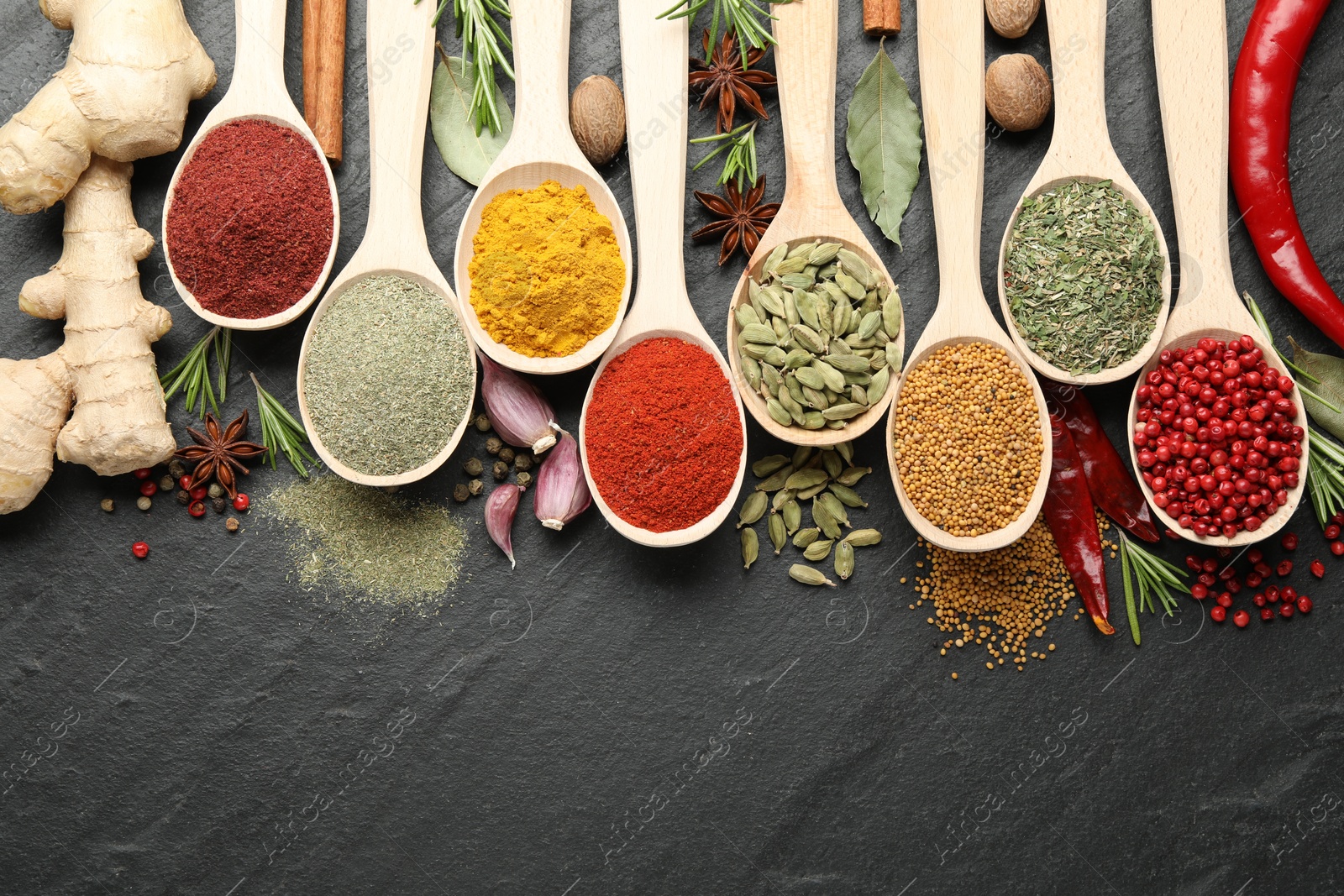 Different aromatic spices in spoons on black table, flat lay. Space for text Photo of Different aromatic spices in spoons on black table, flat lay. Space for text