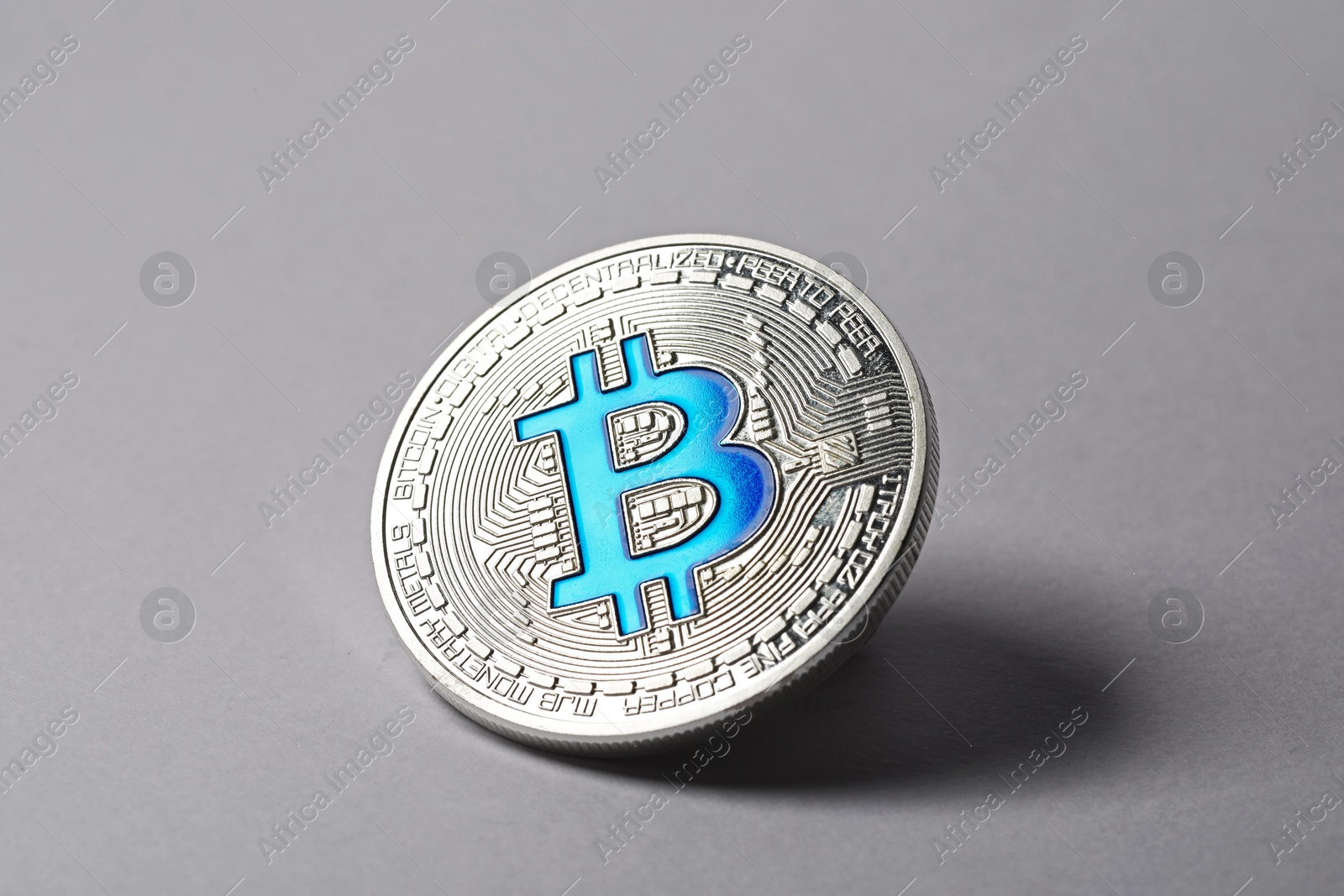 Cryptocurrency. One silver bitcoin on light background, closeup Photo of Cryptocurrency. One silver bitcoin on light background, closeup