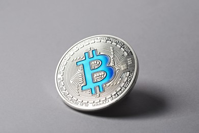 Photo of Cryptocurrency. One silver bitcoin on light background, closeup