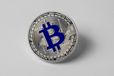 Photo of Cryptocurrency. One silver bitcoin on light background, closeup