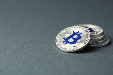 Photo of Cryptocurrency. Many bitcoins on grey background, closeup. Space for text