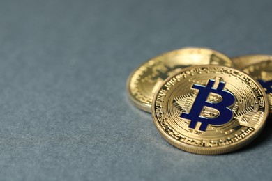 Photo of Cryptocurrency. Many bitcoins on grey background, closeup. Space for text