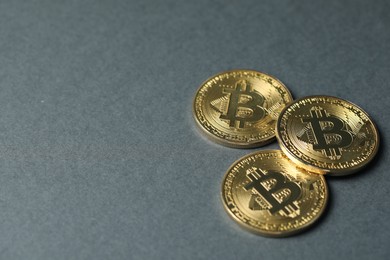 Photo of Cryptocurrency. Many bitcoins on grey background, closeup. Space for text