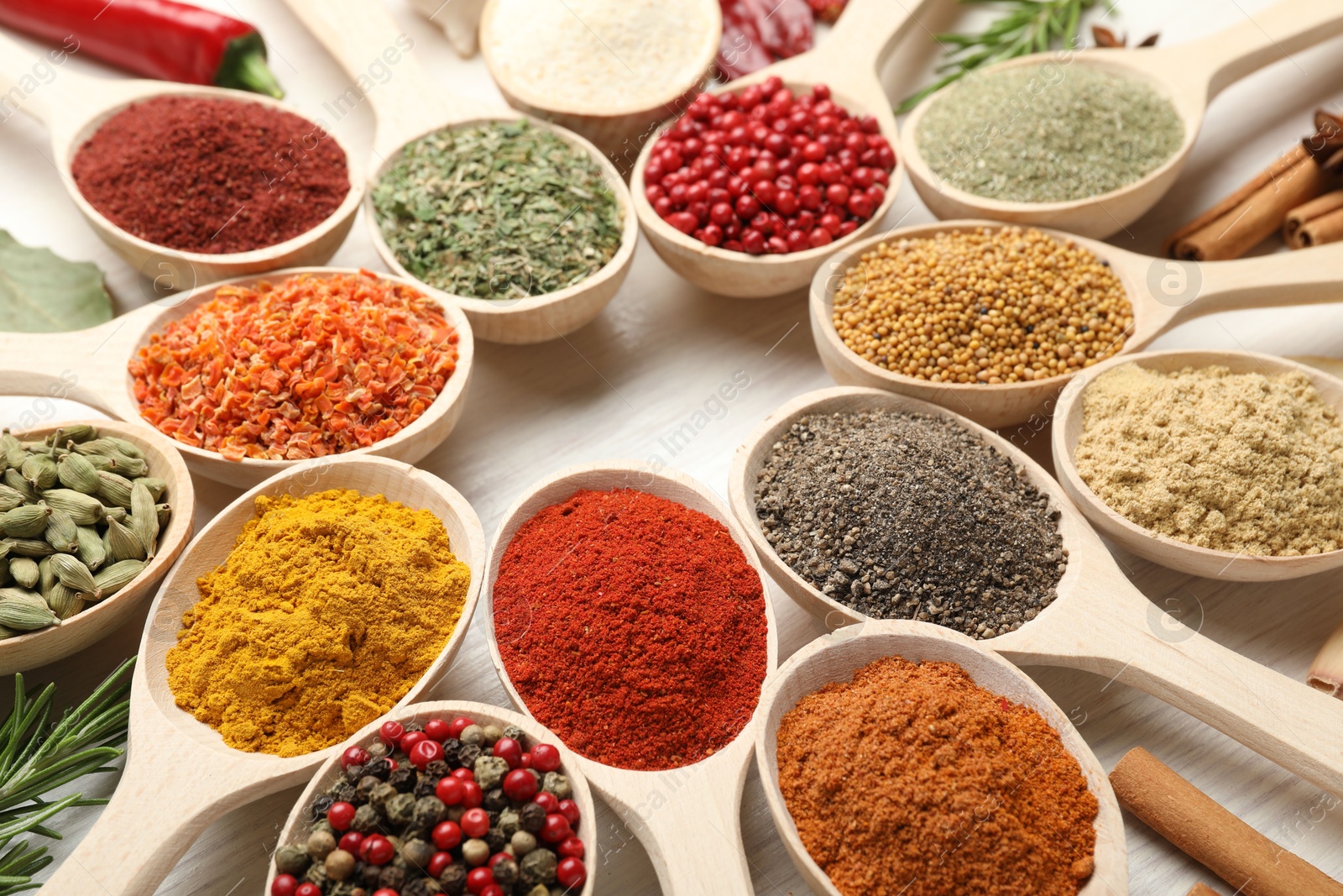 Different aromatic spices in spoons on white wooden table, closeup Photo of Different aromatic spices in spoons on white wooden table, closeup