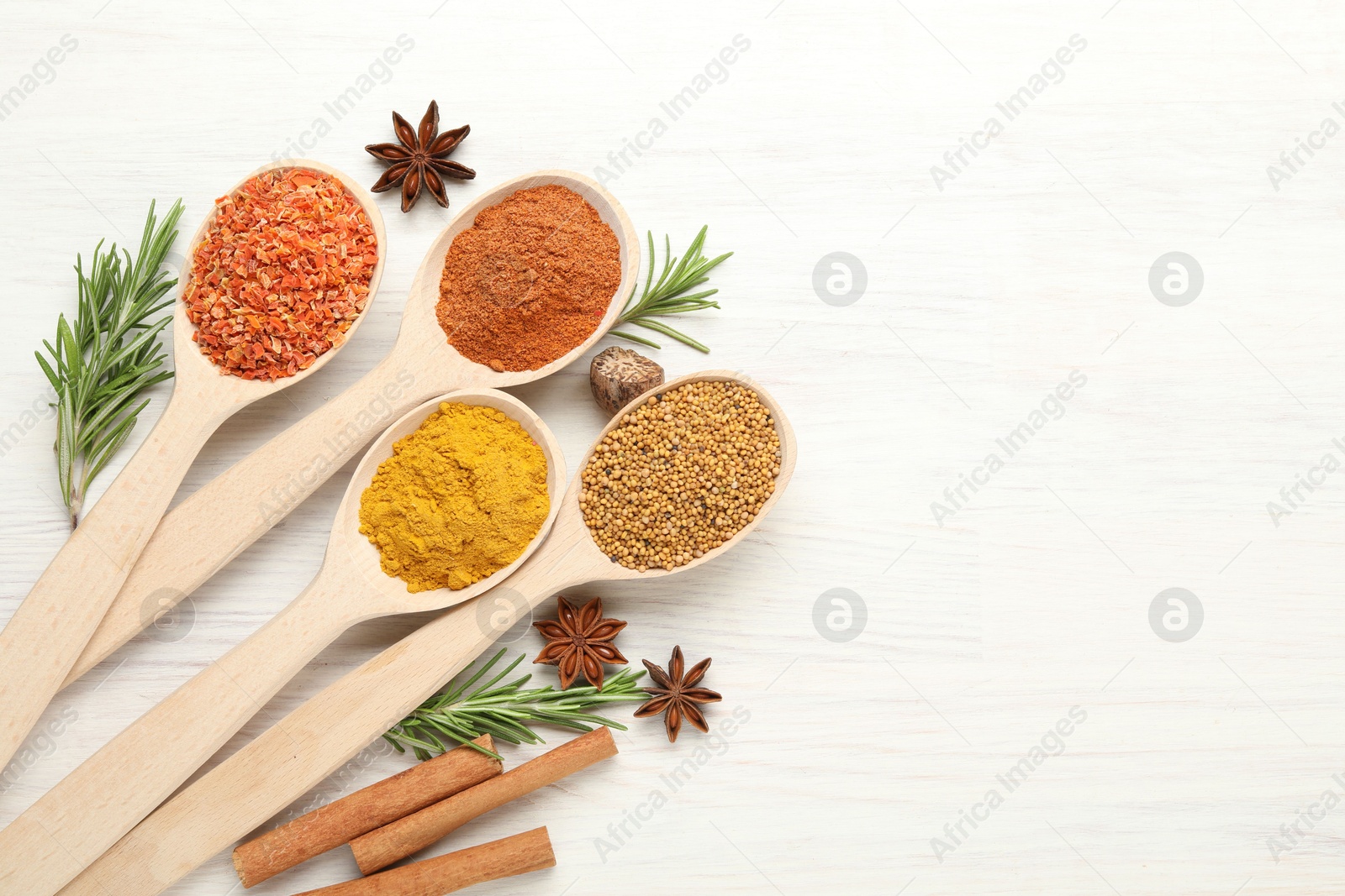 Different aromatic spices in spoons on white wooden table, flat lay. Space for text Photo of Different aromatic spices in spoons on white wooden table, flat lay. Space for text