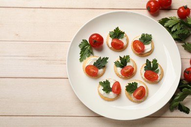 Photo of Tasty crackers with cream cheese, tomatoes and parsley on white wooden table, flat lay. Space for text