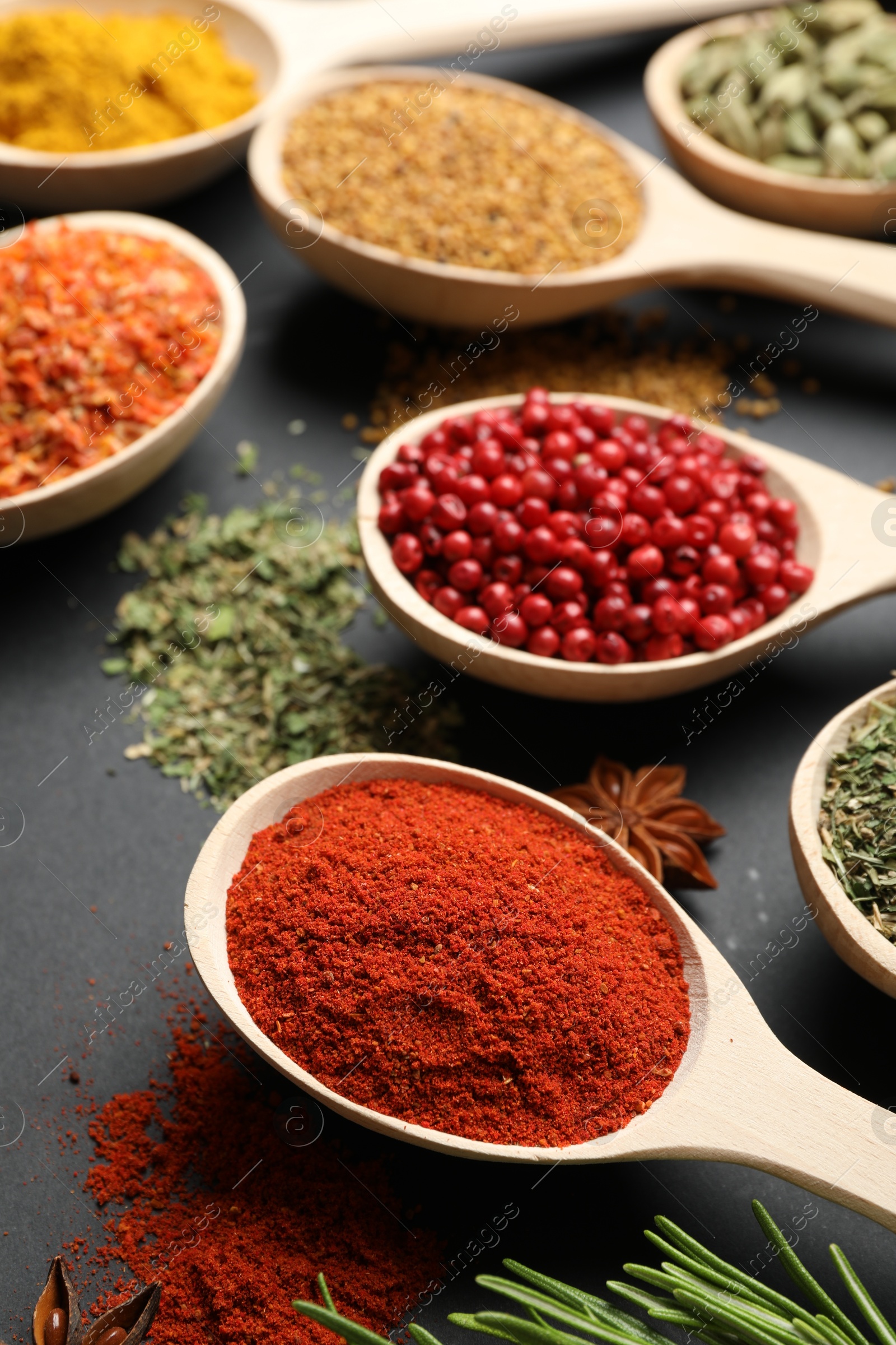 Different aromatic spices in spoons on black table, closeup Photo of Different aromatic spices in spoons on black table, closeup