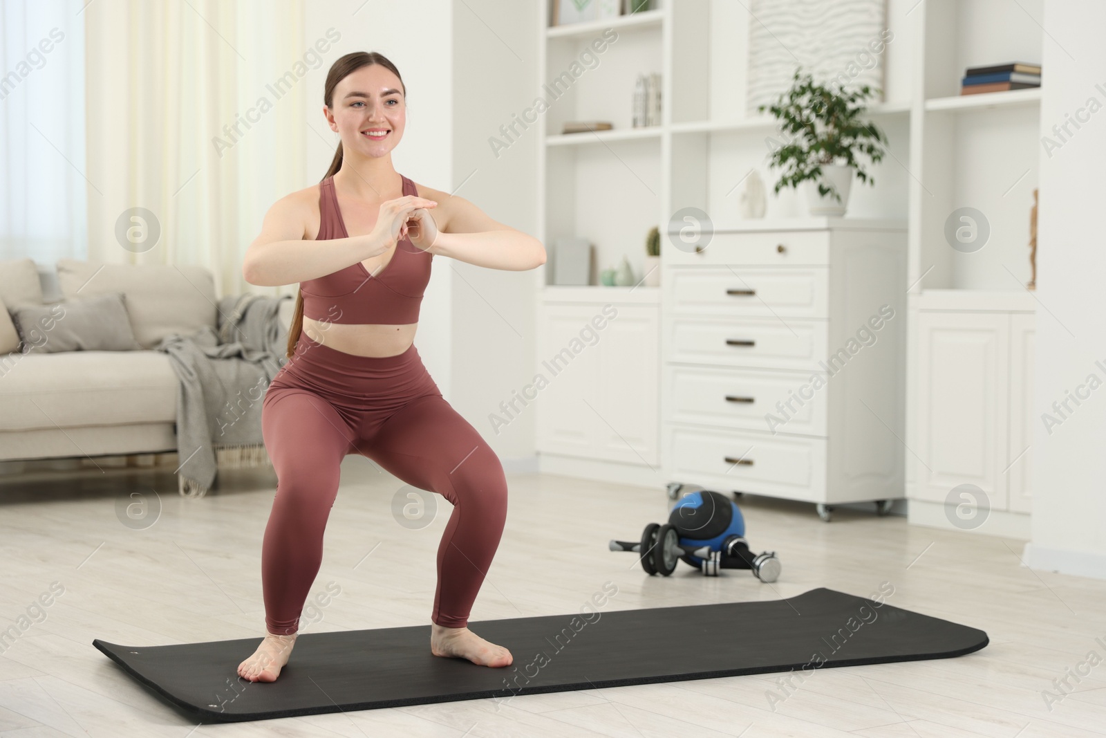 Photo of Beautiful woman exercising on fitness mat at home