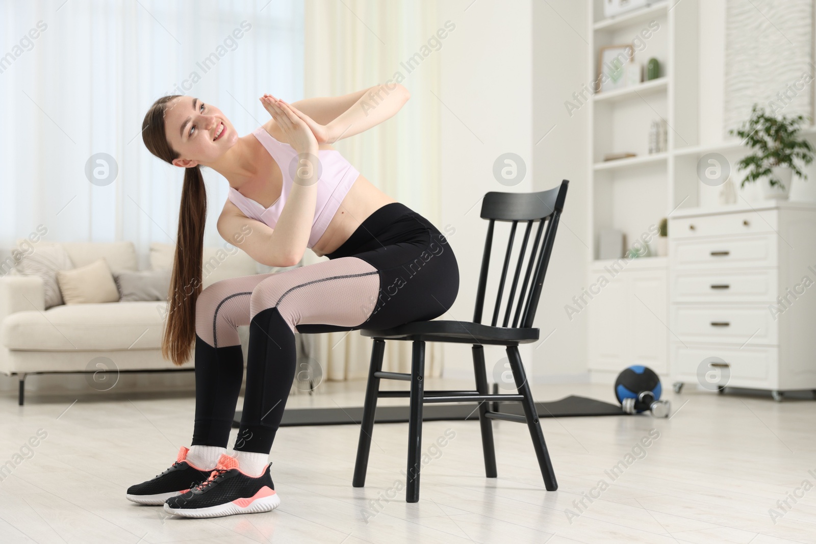 Photo of Beautiful woman stretching on chair at home, space for text
