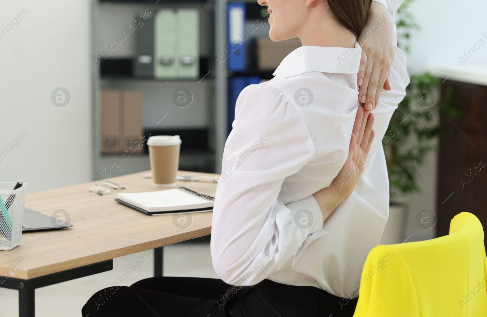Photo of Young woman stretching on chair in office