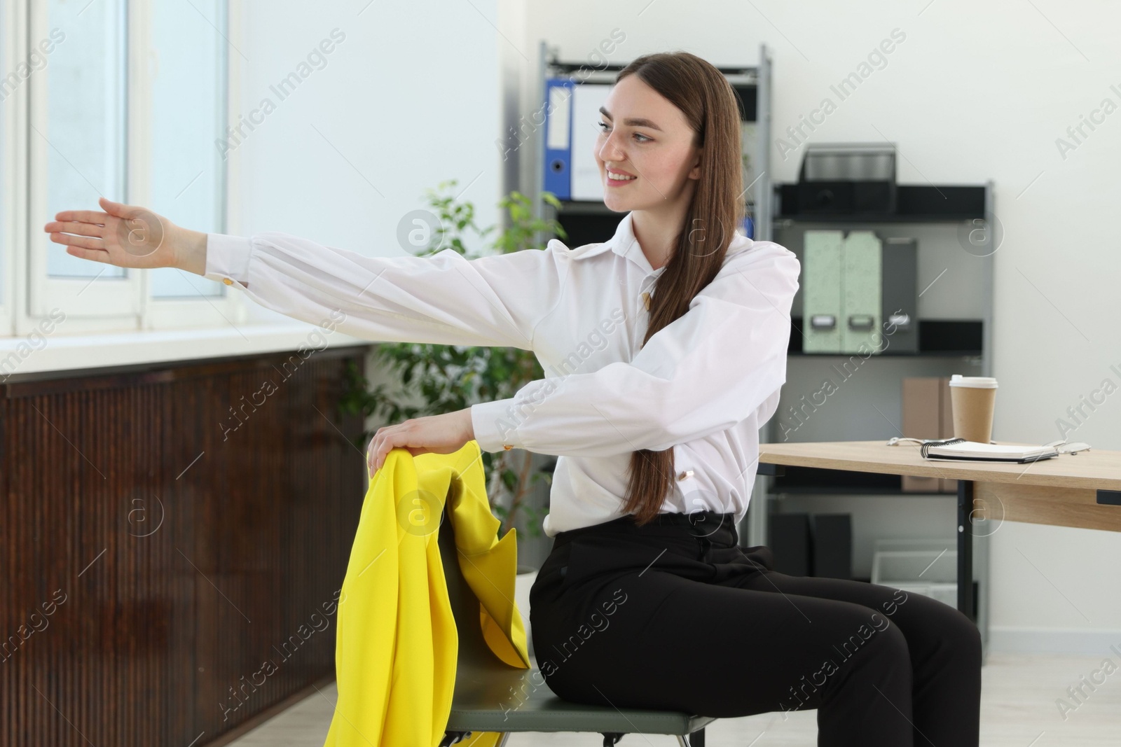 Photo of Beautiful woman stretching on chair in office