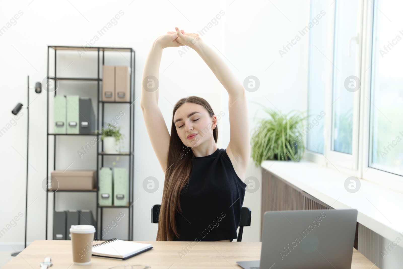 Photo of Beautiful woman stretching on chair in office