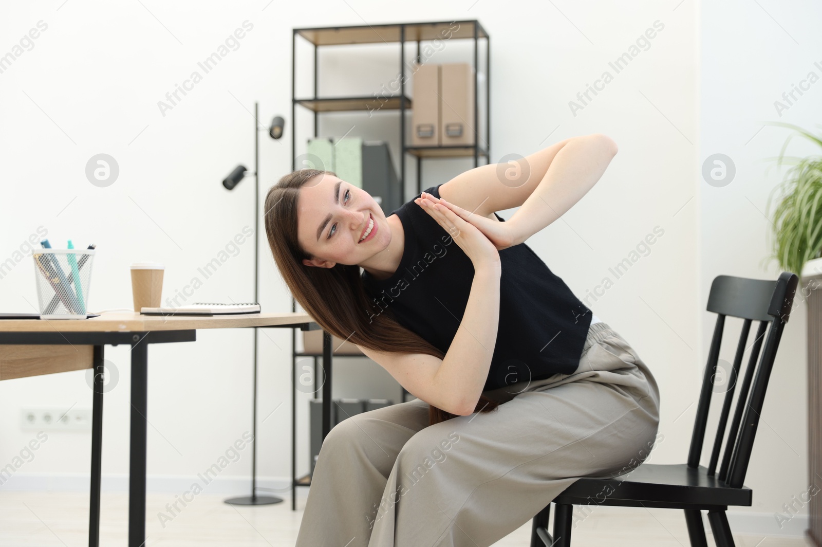 Photo of Beautiful woman stretching on chair in office