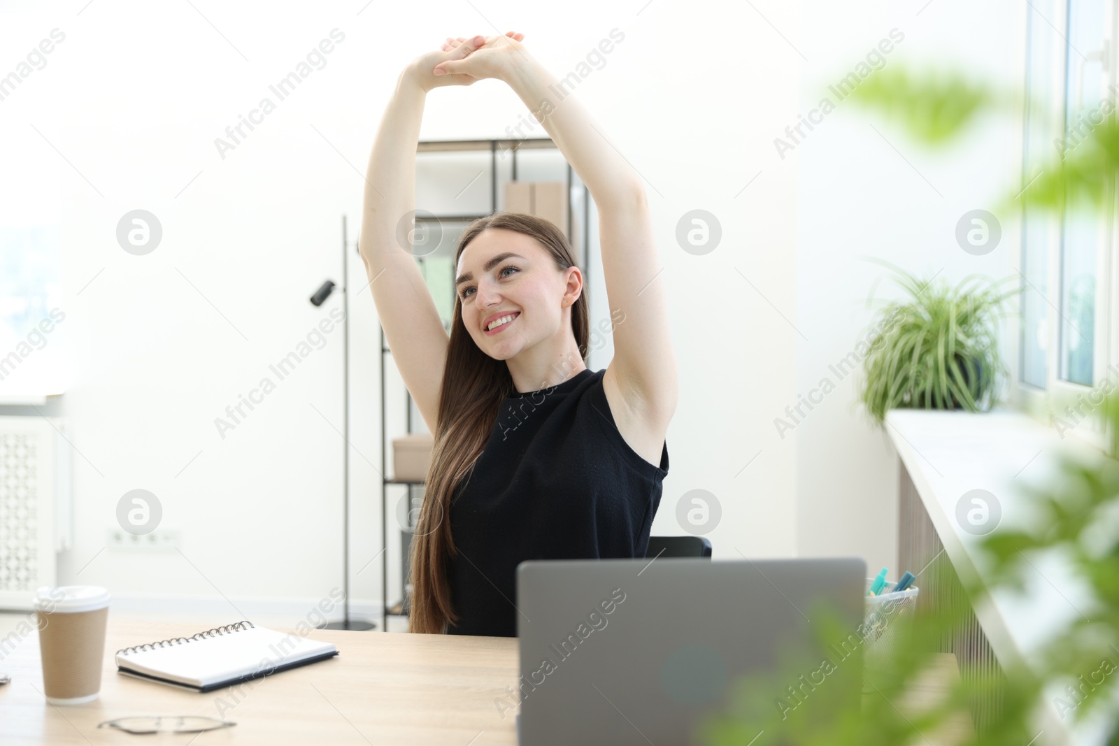 Photo of Beautiful woman stretching on chair in office