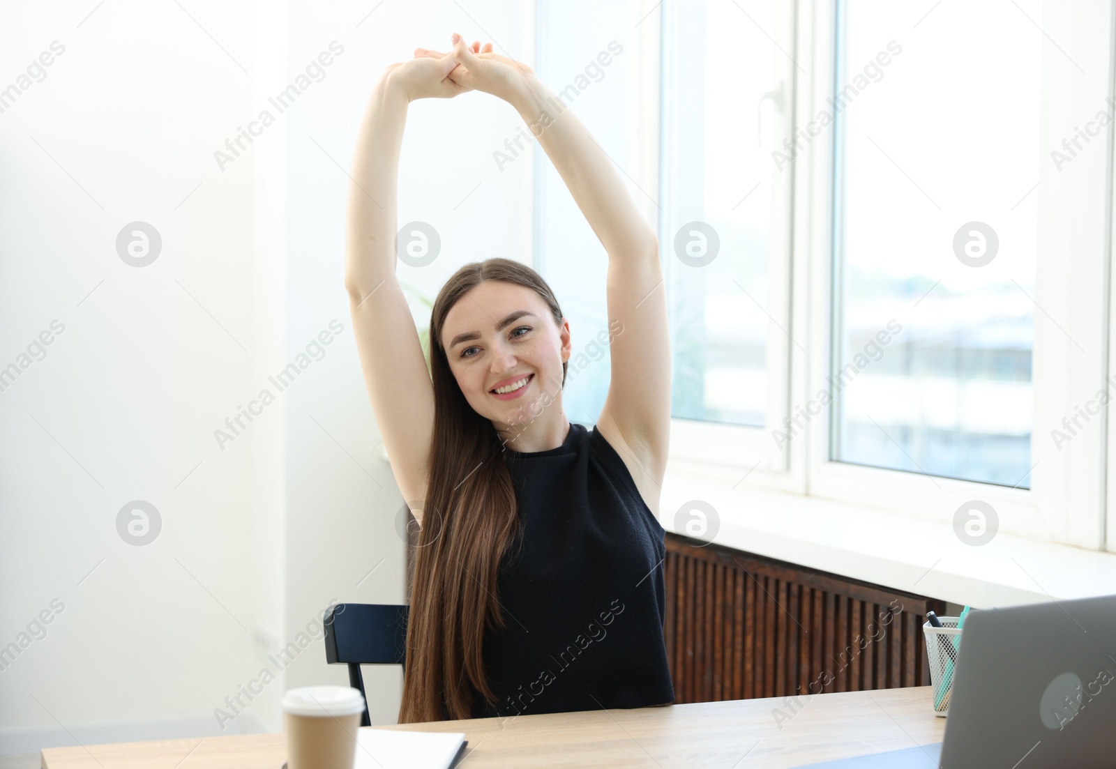 Photo of Beautiful woman stretching on chair in office