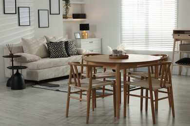Photo of Table, chairs and comfortable sofa indoors. Interior design