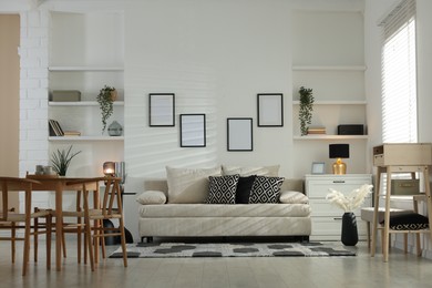 Photo of Comfortable sofa, table, chairs and dresser indoors. Interior design