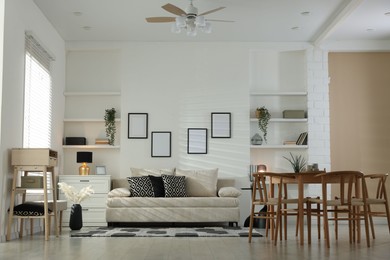 Photo of Comfortable sofa, table, chairs and dresser indoors. Interior design