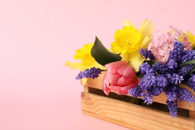 Photo of Beautiful colorful flowers in crate on pink background. Space for text