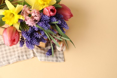 Photo of Beautiful colorful flowers in crate on beige background, above view. Space for text