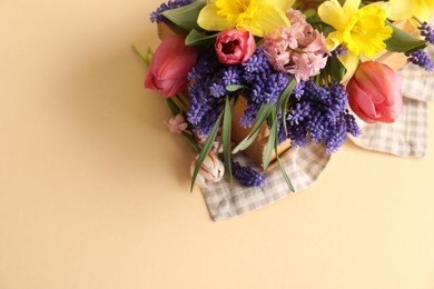 Photo of Beautiful colorful flowers in crate on beige background, above view. Space for text