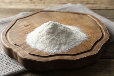 Photo of Pile of wheat flour on wooden table, closeup