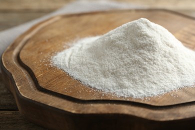 Photo of Pile of wheat flour on wooden table, closeup