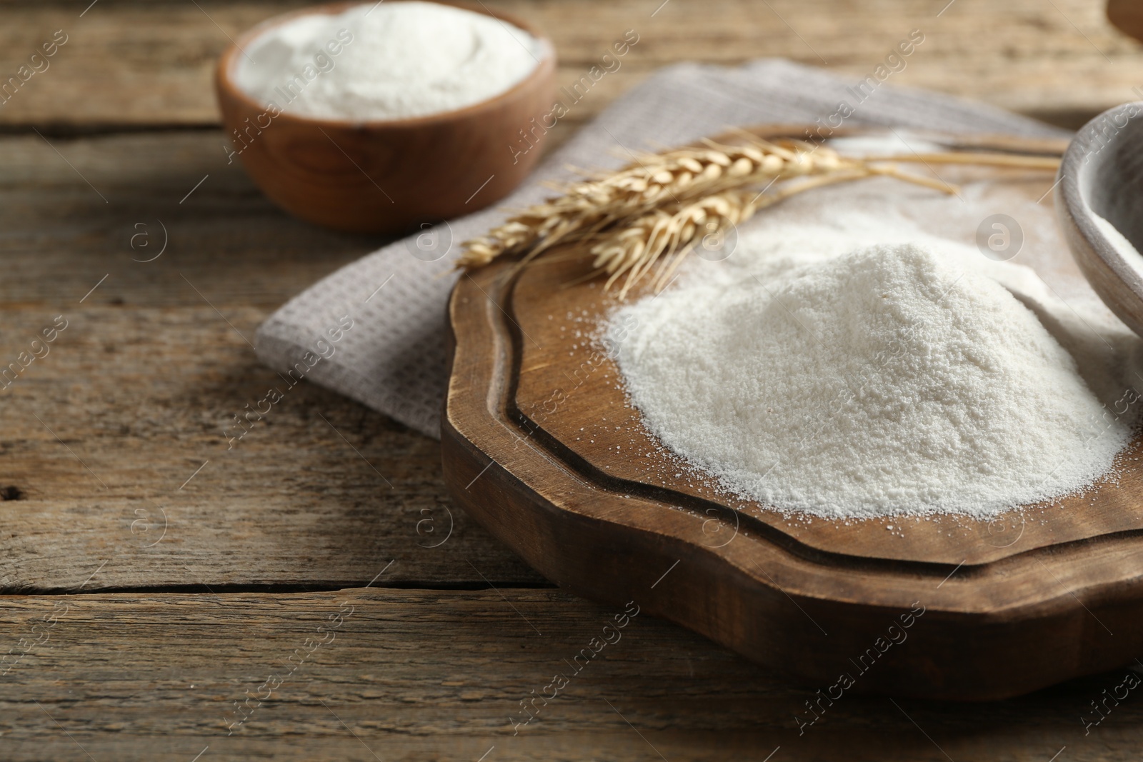 Wheat flour and spikelets on wooden table, closeup Photo of Wheat flour and spikelets on wooden table, closeup