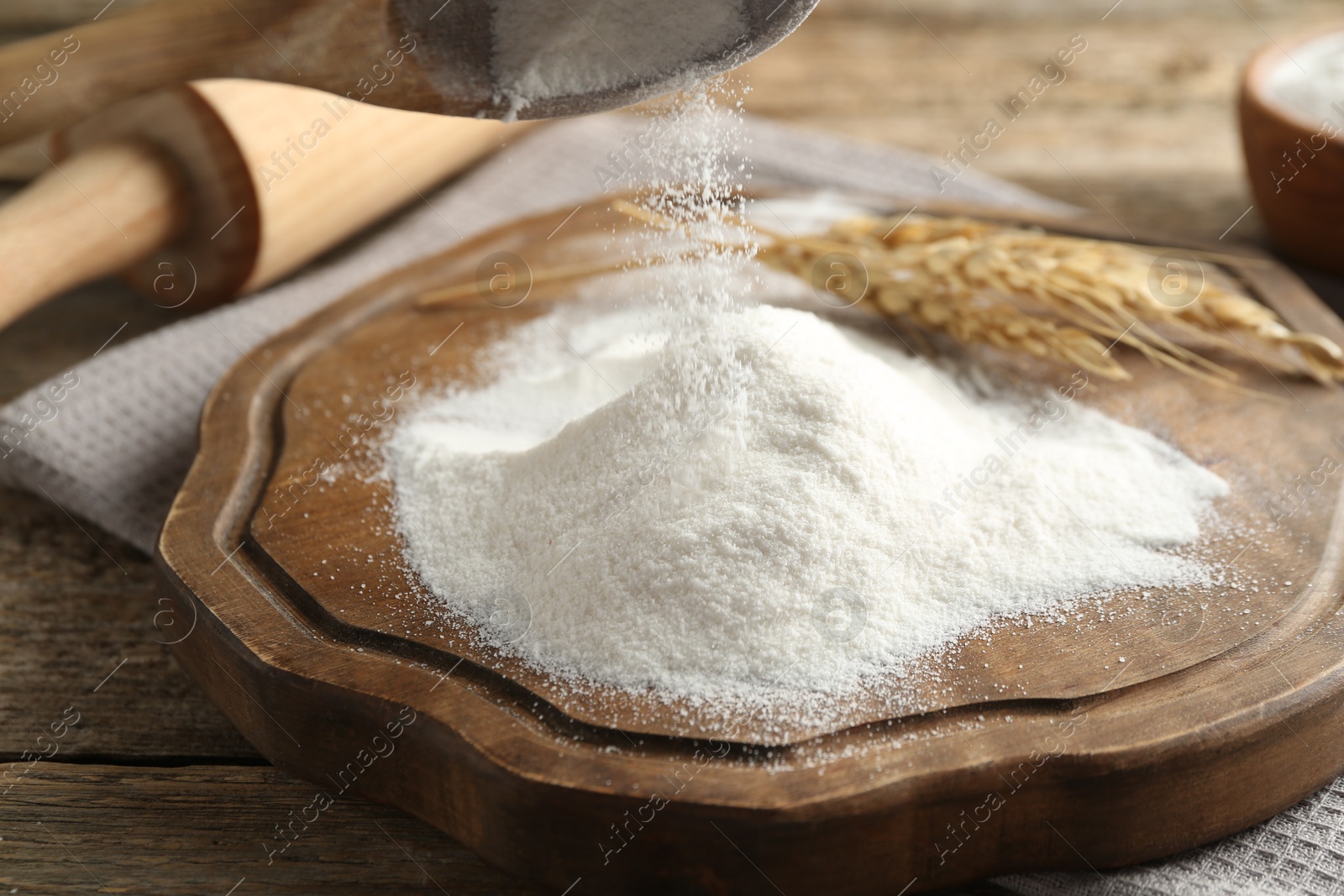 Taking flour with wooden spoon at table, closeup Photo of Taking flour with wooden spoon at table, closeup