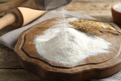 Photo of Taking flour with wooden spoon at table, closeup