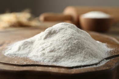 Photo of Pile of wheat flour on wooden board, closeup