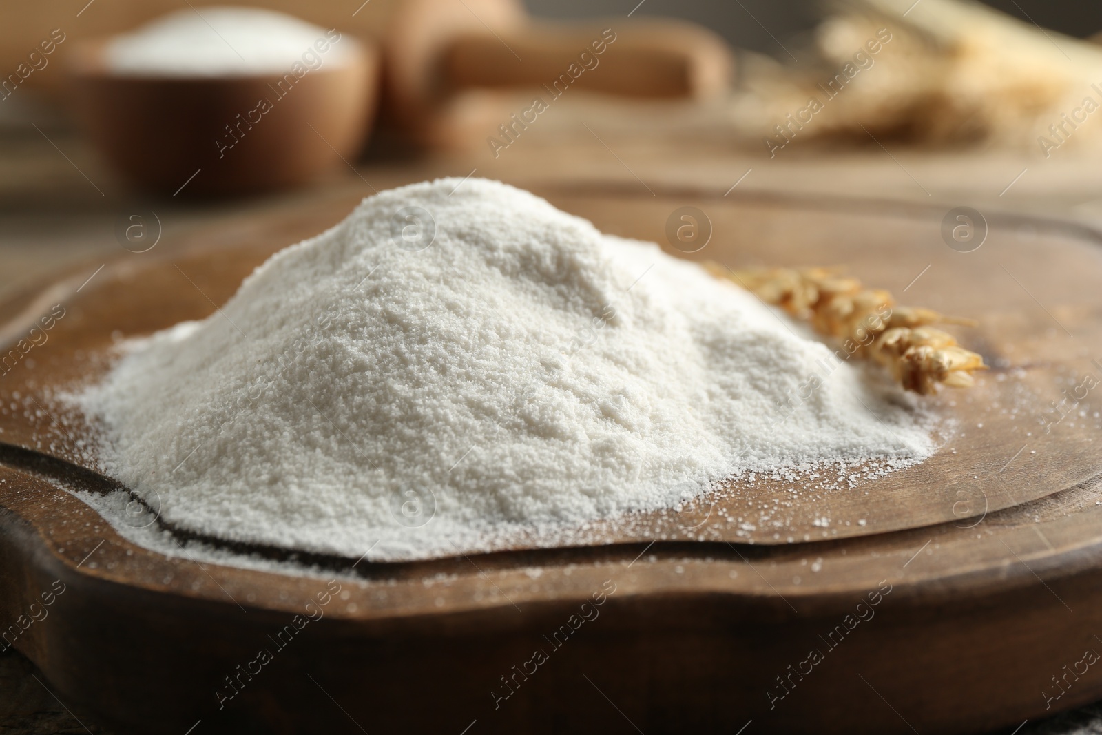 Flour and wheat spikelet on wooden board, closeup Photo of Flour and wheat spikelet on wooden board, closeup