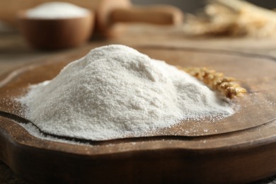 Photo of Flour and wheat spikelet on wooden board, closeup