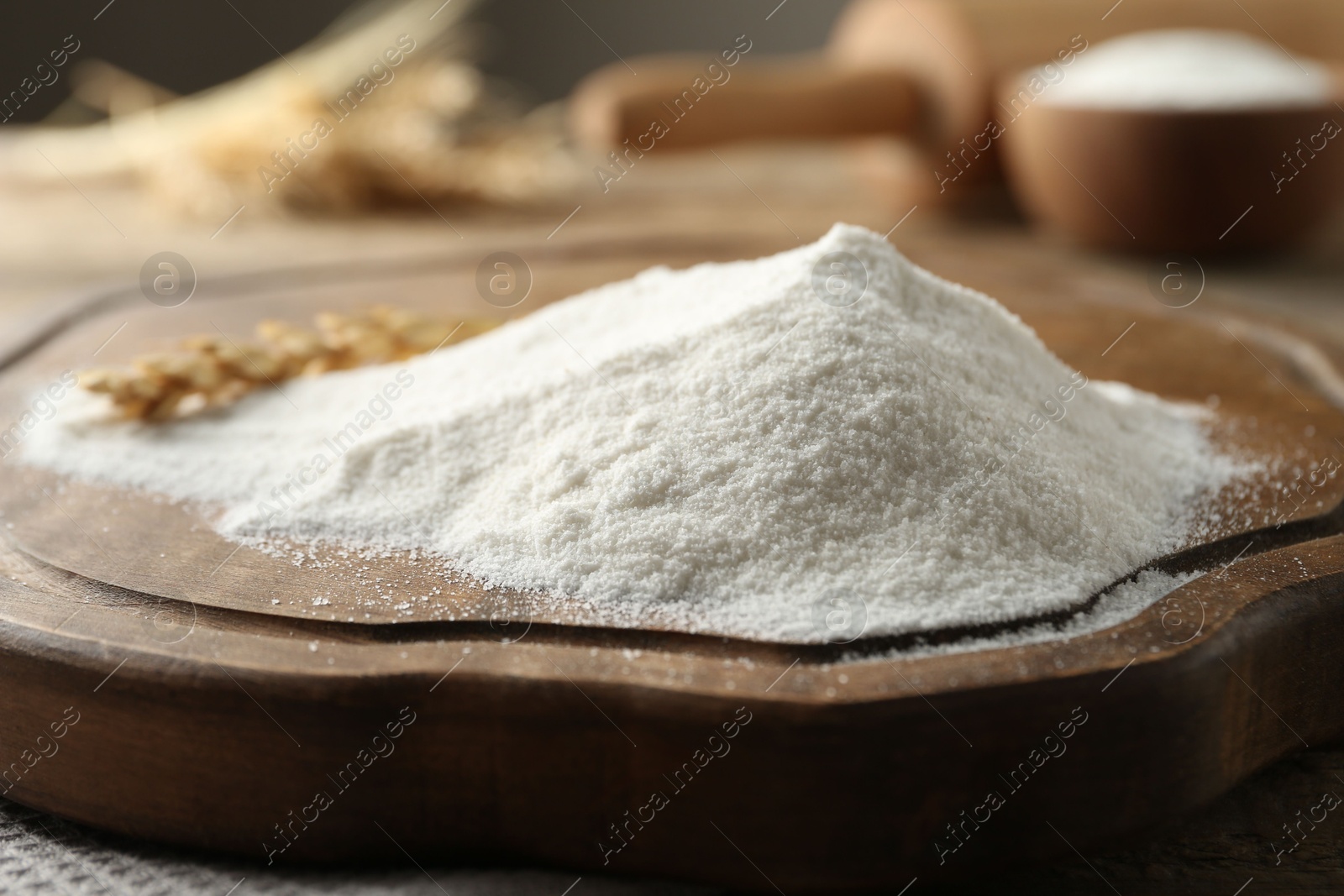 Flour and wheat spikelet on wooden board, closeup Photo of Flour and wheat spikelet on wooden board, closeup