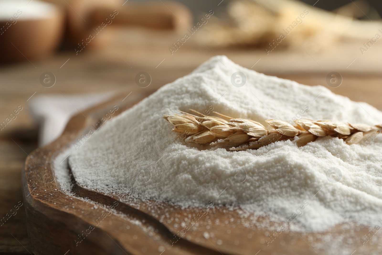 Wheat flour and spikelet on wooden table, closeup Photo of Wheat flour and spikelet on wooden table, closeup
