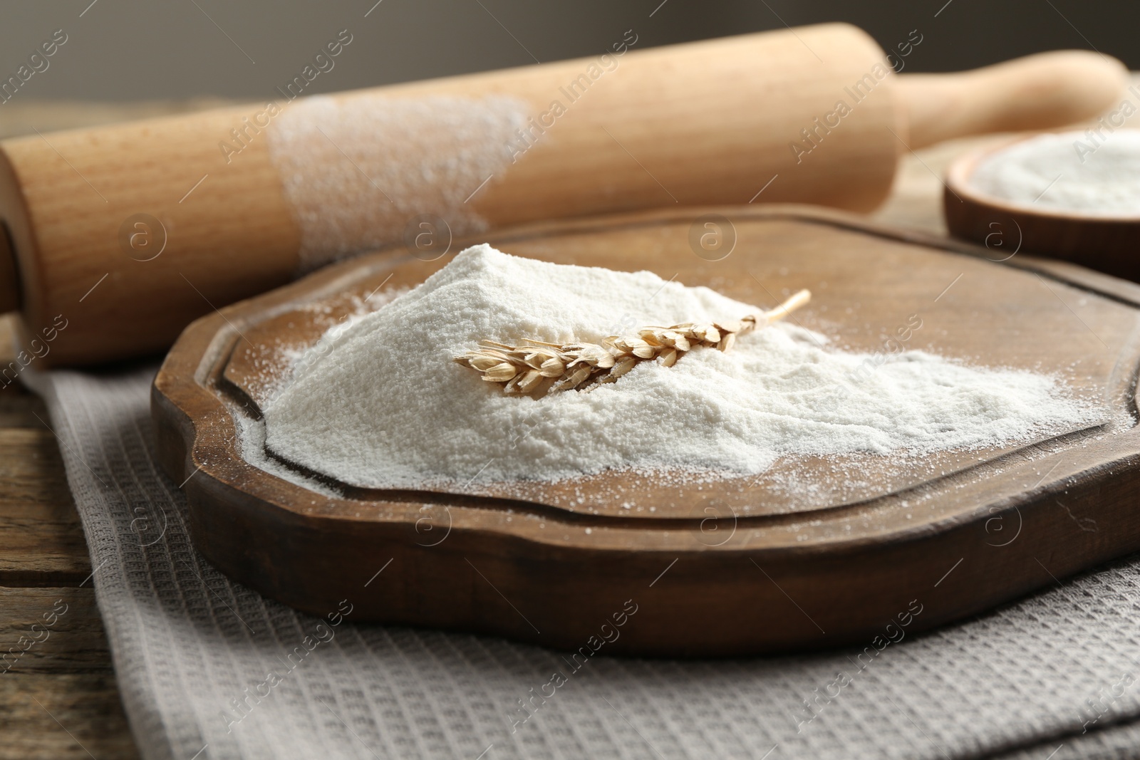 Wheat flour, spikelet and rolling pin on wooden table, closeup Photo of Wheat flour, spikelet and rolling pin on wooden table, closeup