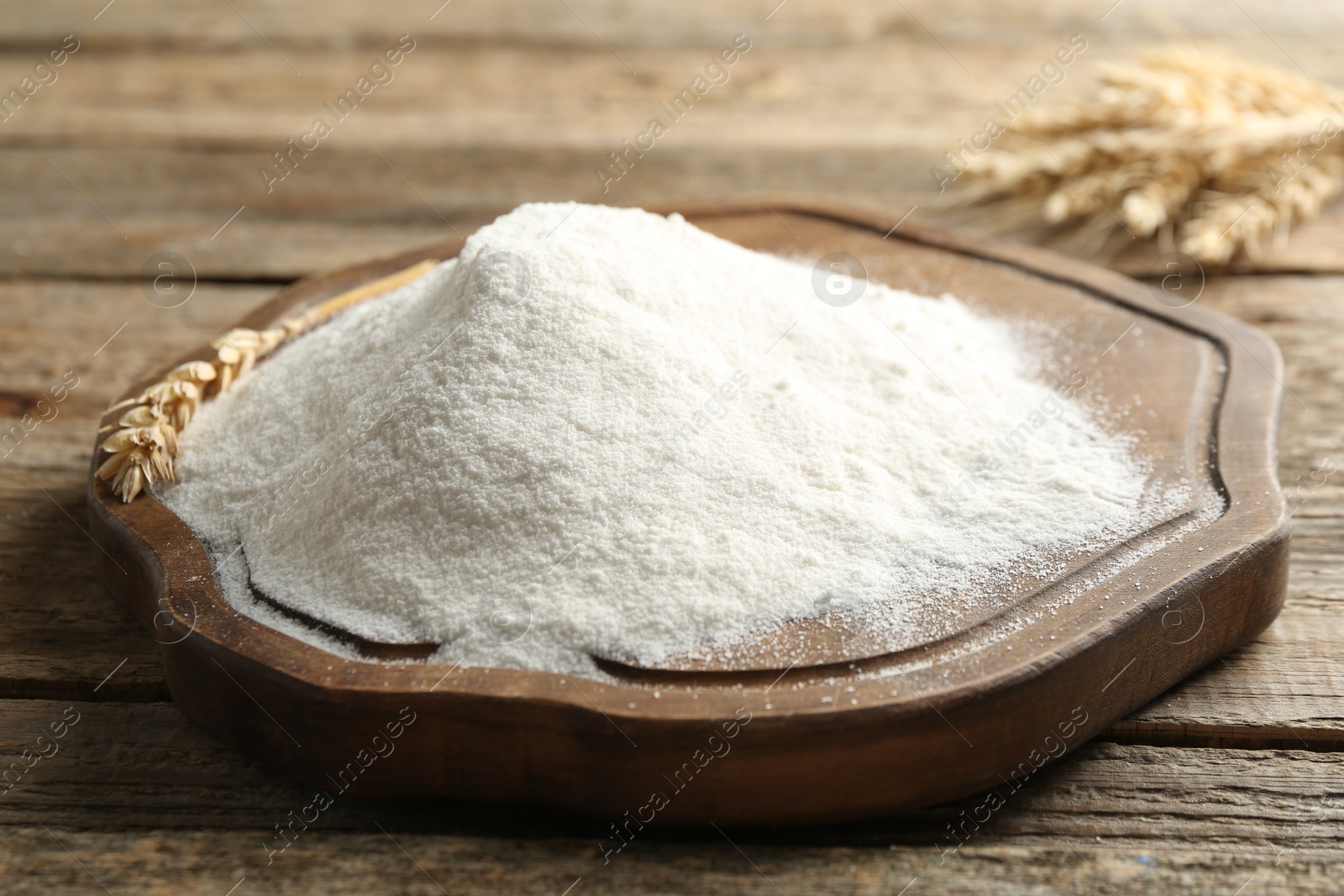 Wheat flour and spikelets on wooden table, closeup Photo of Wheat flour and spikelets on wooden table, closeup