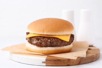 Photo of Cheeseburger with tasty patty on white table, closeup
