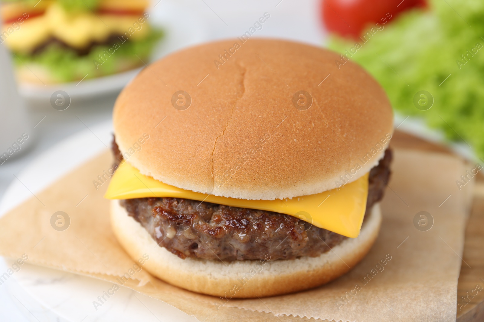 Cheeseburger with tasty patty on white table, closeup Photo of Cheeseburger with tasty patty on white table, closeup
