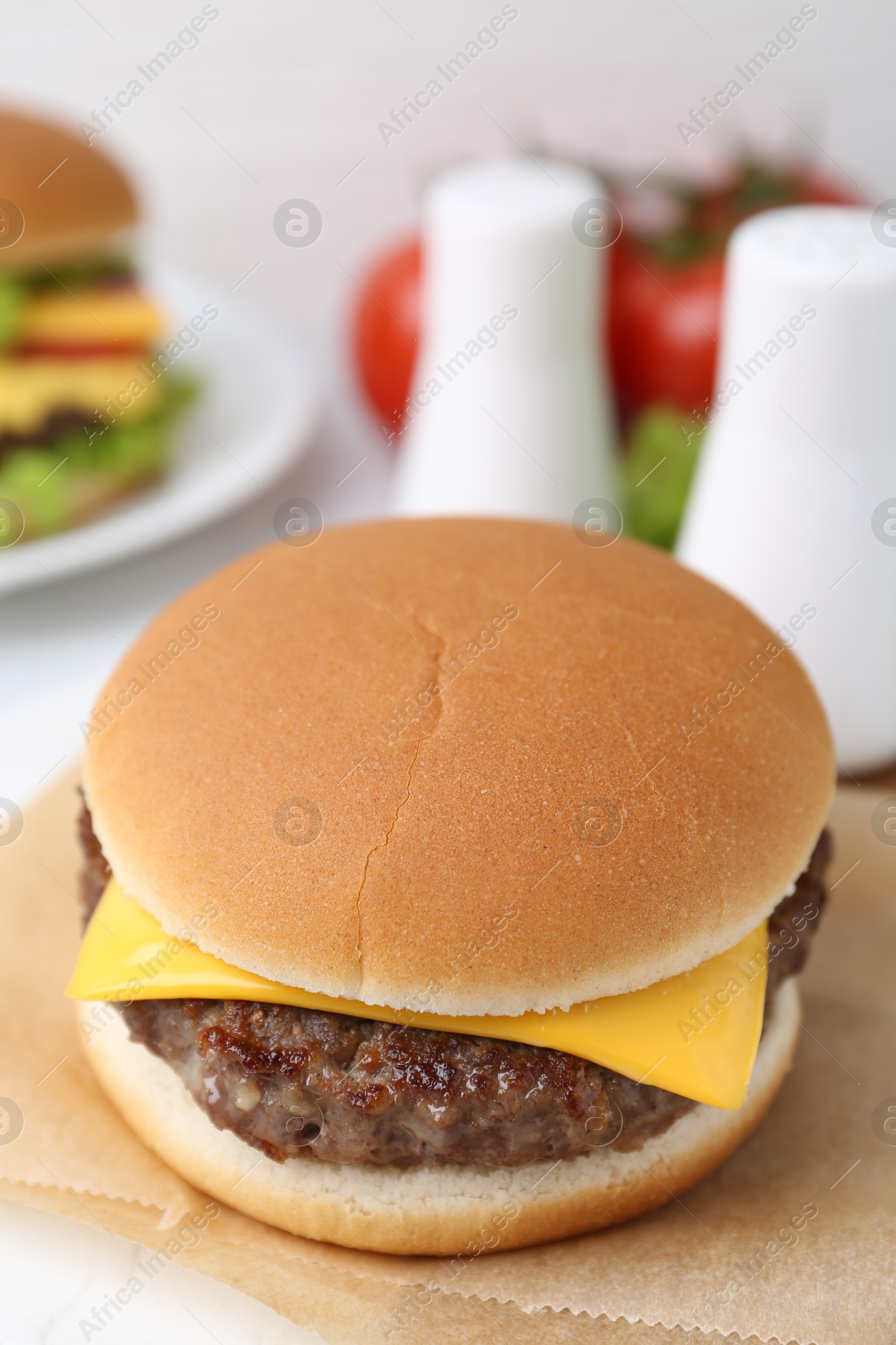 Cheeseburger with tasty patty on white table, closeup Photo of Cheeseburger with tasty patty on white table, closeup