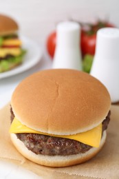 Photo of Cheeseburger with tasty patty on white table, closeup