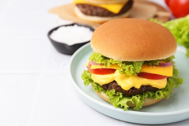 Photo of Tasty cheeseburger on white table, closeup. Space for text