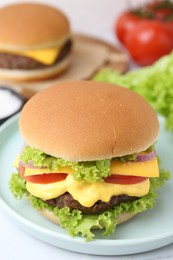 Photo of Tasty cheeseburger with lettuce and tomatoes on white table, closeup