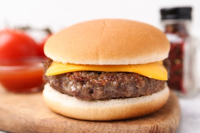Photo of Cheeseburger with tasty patty on white table, closeup