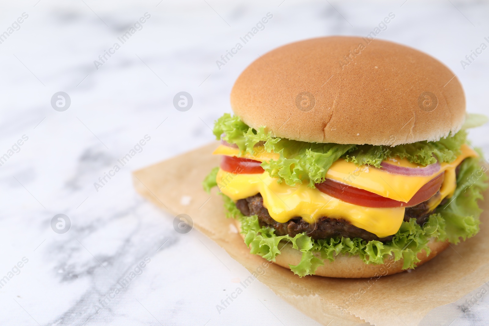 Tasty cheeseburger on white marble table, closeup. Space for text Photo of Tasty cheeseburger on white marble table, closeup. Space for text