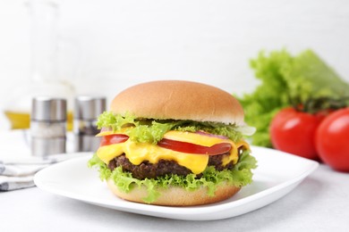 Photo of Tasty cheeseburger with lettuce and tomatoes on white table, closeup