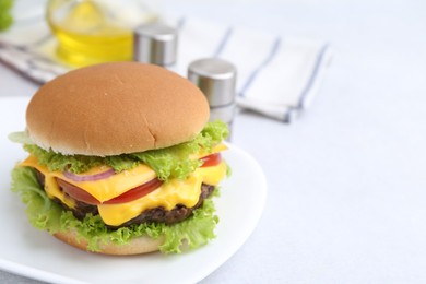 Photo of Tasty cheeseburger on white table, closeup. Space for text